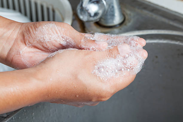 istock Woman washing her hands with soap over sink 488442646