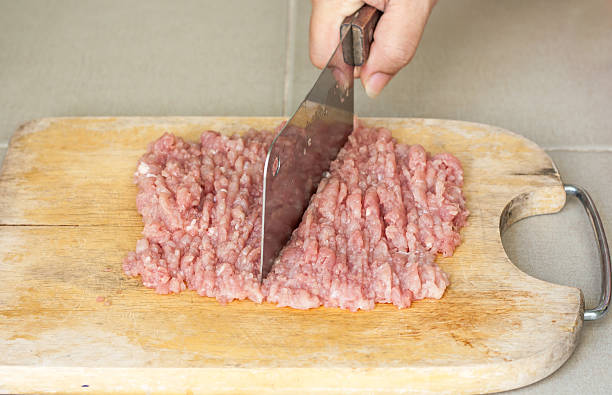 istock making pork chops on wooden cutting board 488442940