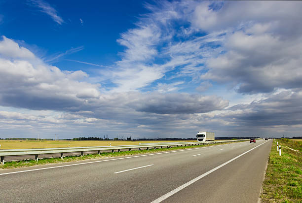 istock Highway among fields on a background of sky 488443302