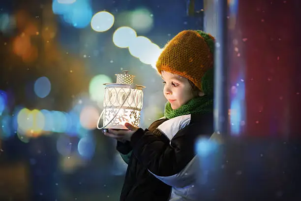 Cute boy, holding lantern outdoor, wintertime