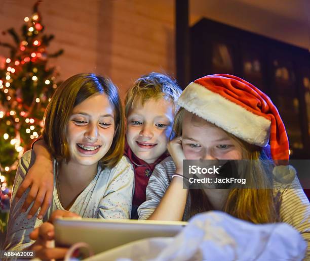 Christmastime Hermanos Y Hermanas Divirtiéndose En Una Tableta Digital Foto de stock y más banco de imágenes de Adolescente