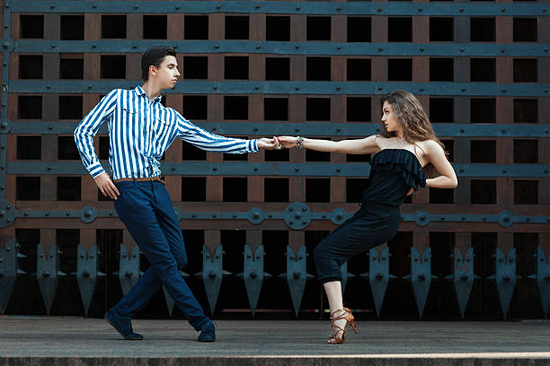 istock Guy with a girl dancing in the street dancing. 488464284