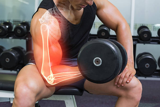 Highlighted arm of strong man lifting weights stock photo