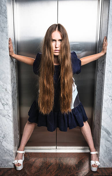 istock Fashion woman posing against the elevator 488465068