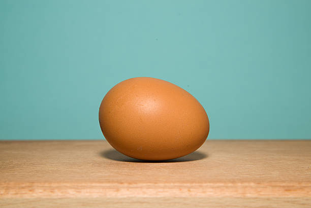 istock Brown chicken egg is on a wooden surface 488469026