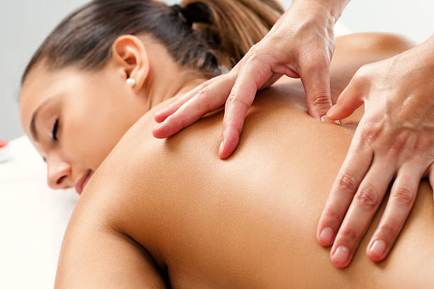 Therapist applying pressure with thumbs on back. Close up of Therapist doing curative healing massage with thumbs on female back. chiropractic adjustment photos stock pictures, royalty-free photos & images