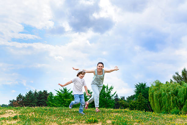 istock Happy Mother and son running on grass smiling 488471114