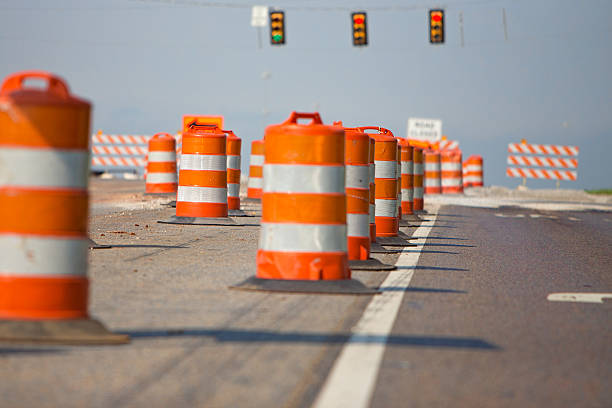 Line of road cones Front and back cones are out of focus, center of the image is sharp focus. Driver's perspective. road closed sign horizontal road nobody stock pictures, royalty-free photos & images