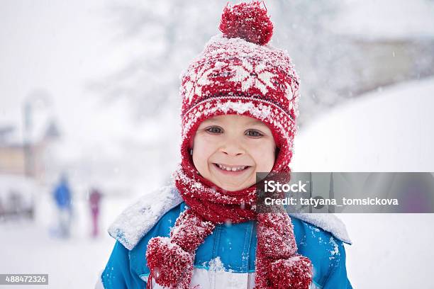 Linda Little Boy In Blue Traje De Invierno Tocando Al Aire Libre Foto de stock y más banco de imágenes de Invierno