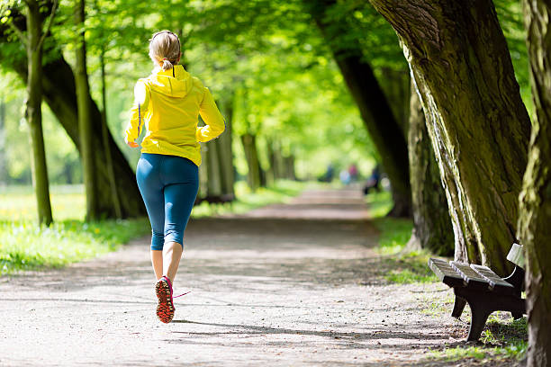 Woman runner running jogging in summer park stock photo