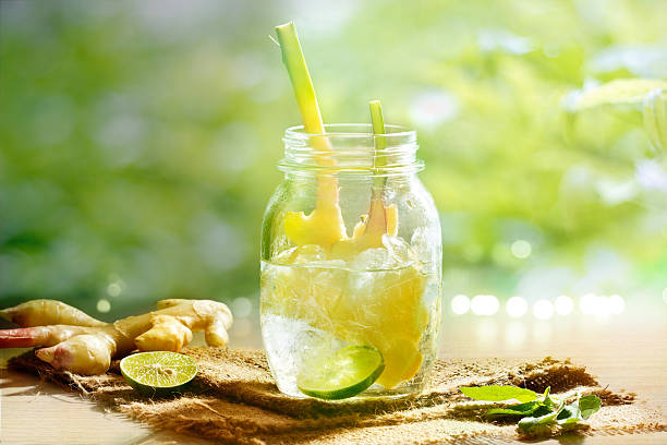 vibrant and colorful ginger with lemon detox water and herb vibrant and colorful ginger with lemon detox water and herb in the morning on green nature background lime basil plant stock pictures, royalty-free photos & images
