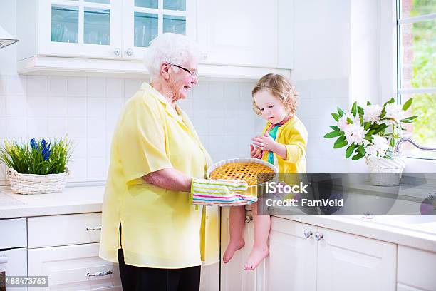 Sweet Granddaughter With Her Pretty Great Grandmother Baking Apple Pie Stock Photo - Download Image Now