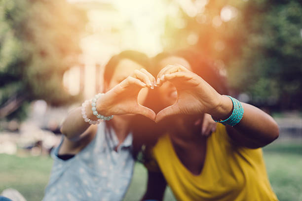 Girls making heart with hands Young women showing a heart-shape symbol with hands heart hands multicultural women stock pictures, royalty-free photos & images