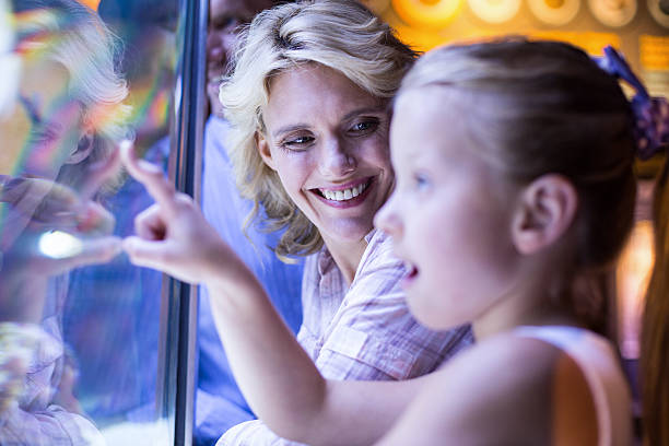 istock Happy family looking at starfish in a tank 488473904