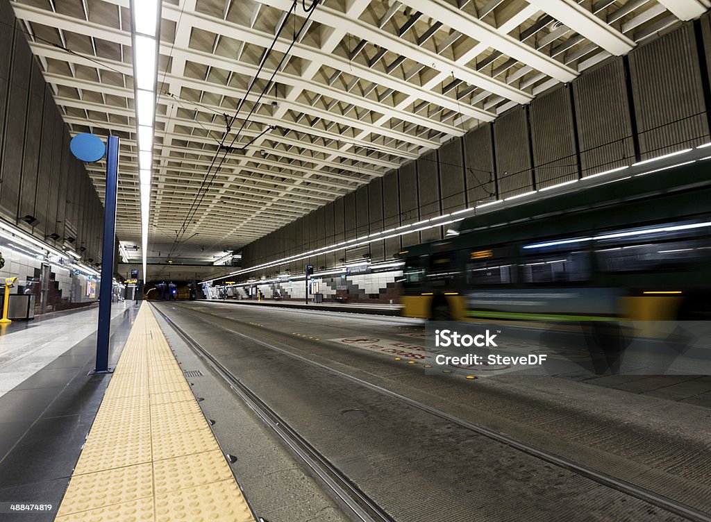 Bus passes by in an indoor transportation station Bus is blurred as it passes by a stop on an underground combined bus and light rail station in Downtown Seattle. Blurred Motion Stock Photo