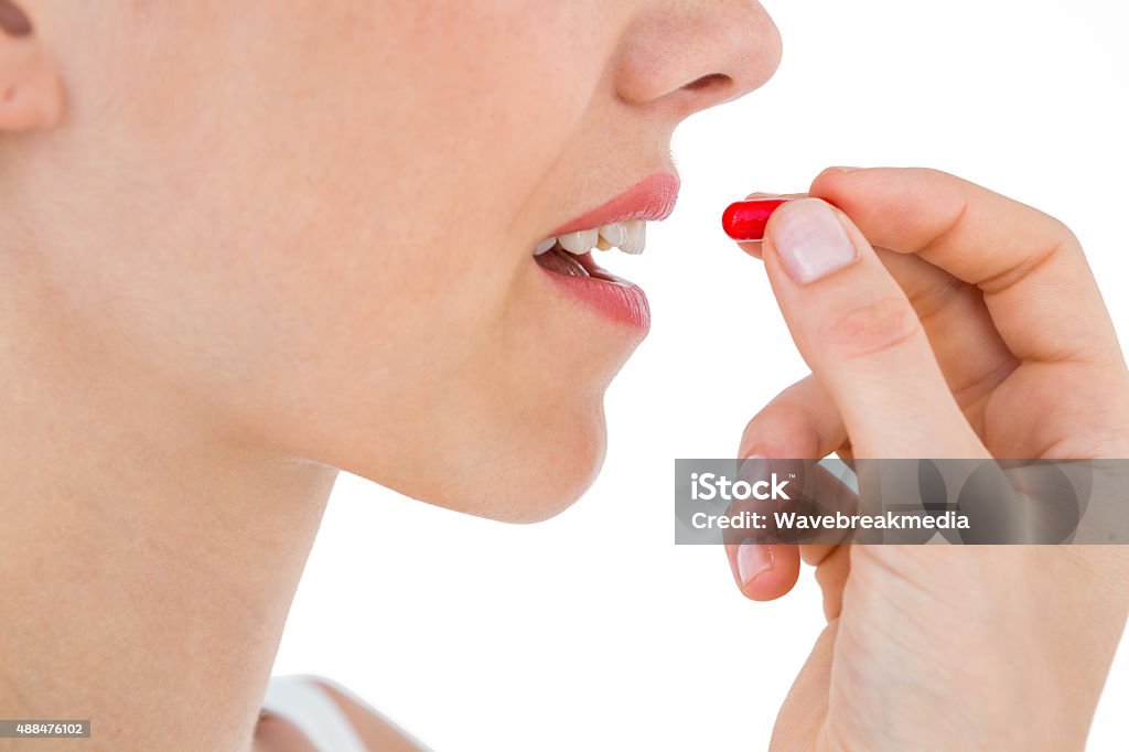 Pretty Woman Ready To Swallow Red Pill Stock Photo - Download Image Now - 2015, Adult, Beautiful People iStock