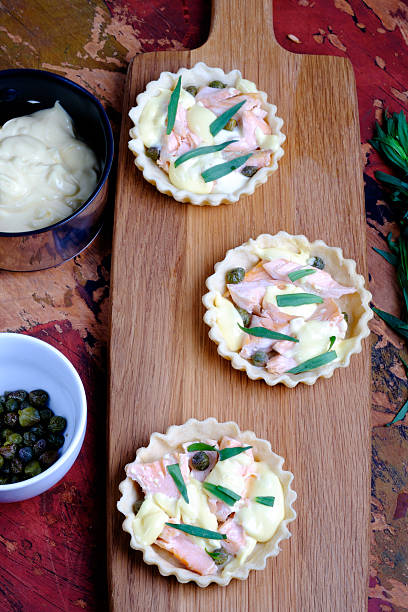 Salmon and hollandaise mini tarts Salmon and hollandaise mini tarts with capers and tarragon hollandaise sauce stock pictures, royalty-free photos & images