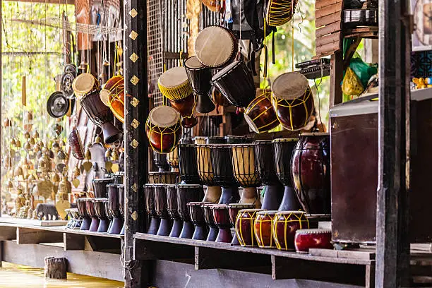 hanged thai drums on sale in a stall of the damnoen saduak floating market in Ratchaburi, Thailand