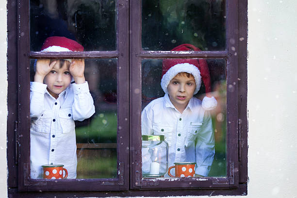 istock Two cute boys, looking through a window, waiting for Santa 488479546
