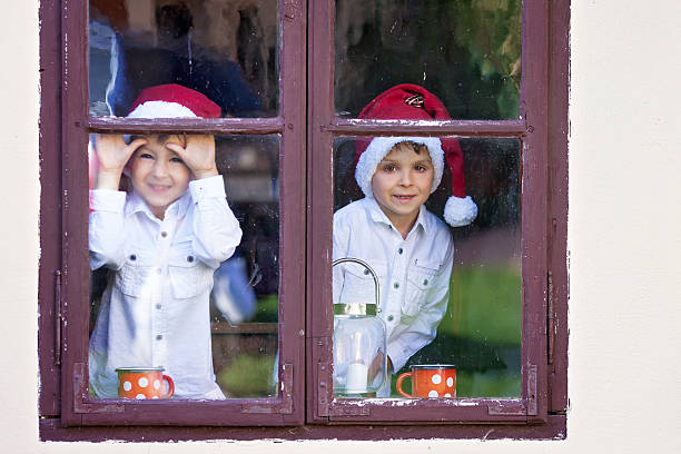 istock Two cute boys, looking through a window, waiting for Santa 488479592