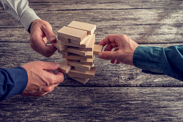 istock Three Businessmen Playing Wooden Tower Game 488480330