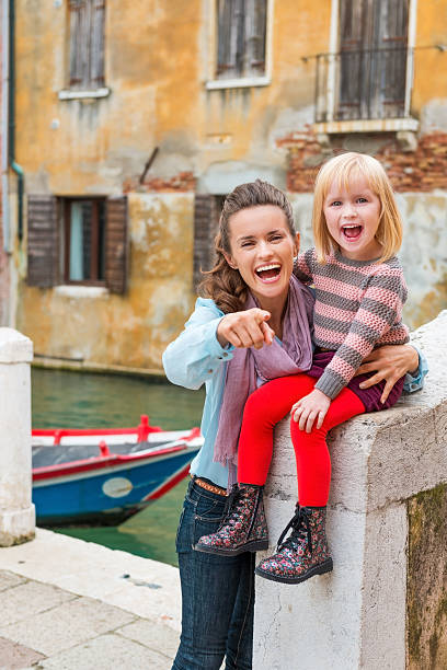 istock Happy, smiling mother pointing while holding happy daugther 488482764