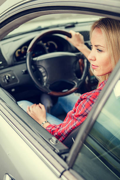 istock Beautiful young woman sitting in car 488487792