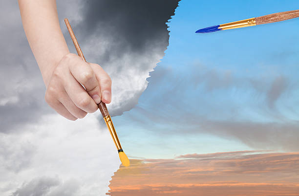 istock paintbrush paints sunset sky instead of rainy clouds 488492674