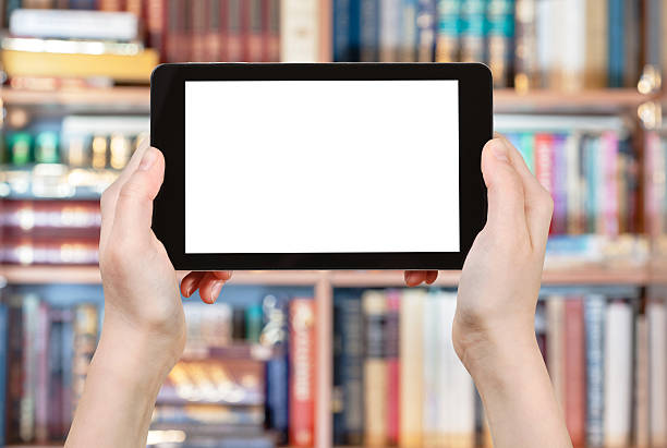 istock hands holding tablet pc in front of books 488495610