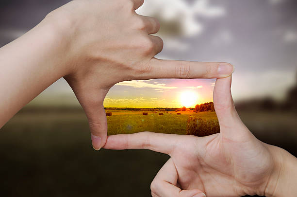 clear vision of a sunset out of focus nature and fingers creating a square making the scenery better focus stock pictures, royalty-free photos & images