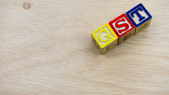 Mix color of GST wooden alphabetical letters block on wooden surface
