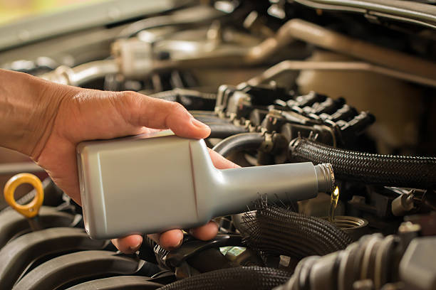 istock Mechanic pouring concentrated oil into car. 488497742