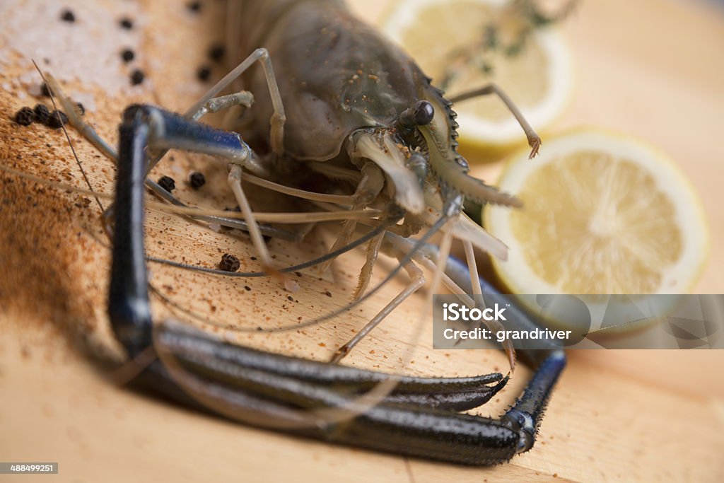 Whole Jumbo Shrimp Whole jumbo shrimp or prawn on a cutting board with lemon and seasonings preparing for cooking Boiled Stock Photo