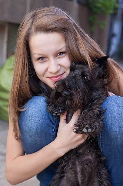 istock Young beautiful girl with her miniature schnauzer 488502495