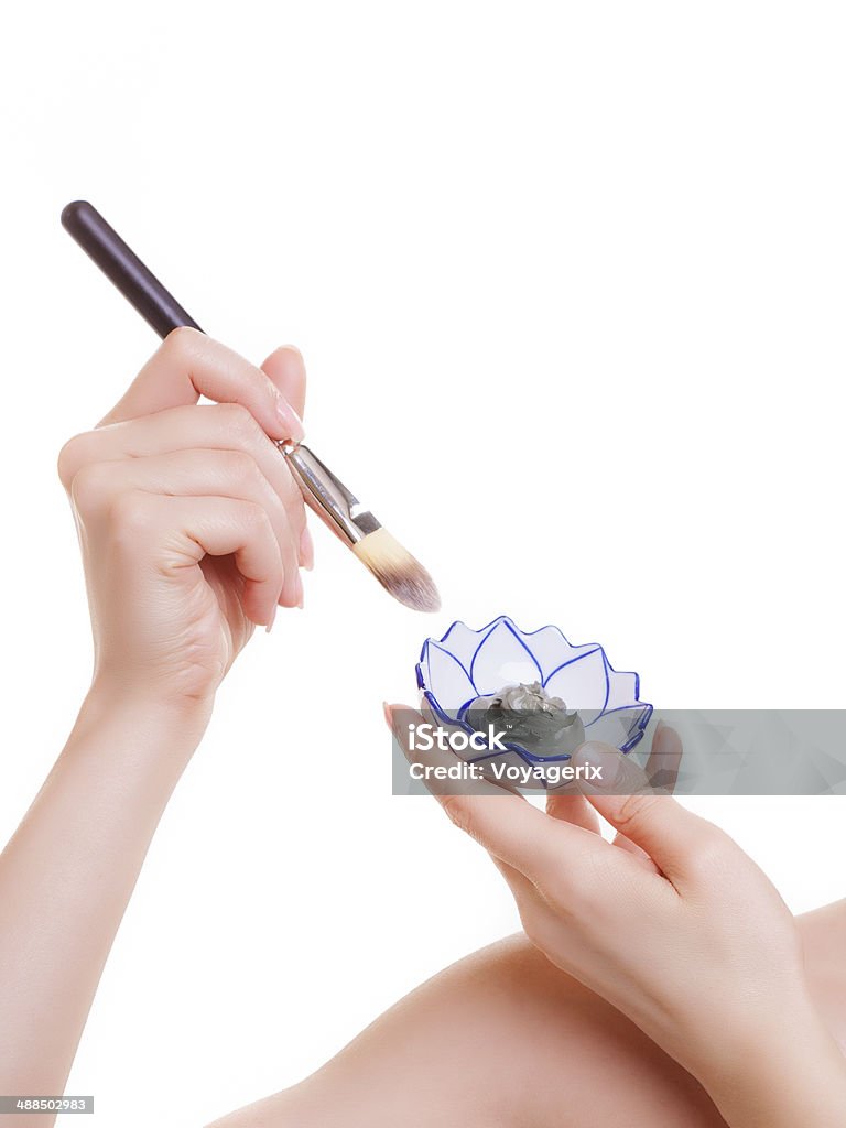 Skin care. Woman applying clay mask on face. Spa. Skin care. Closeup of cosmetic. Young woman with brush applying clay mask on her face. Girl taking care of her dry compexion. Isolated. Spa and beauty treatment. Adult Stock Photo