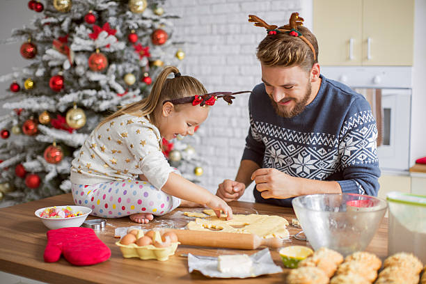 padre e hija cocinar en la cocina de navidad. - christmas child cookie table fotografías e imágenes de stock