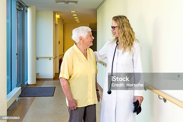 Doctor Chatting To An Elderly Lady Patient Stock Photo - Download Image Now - 2015, Adult, Aging Process