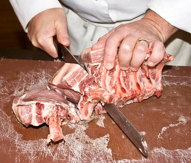 Butcher Slicing Raw Meat