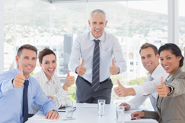 istock Business team smiling at camera showing thumbs up 488512296