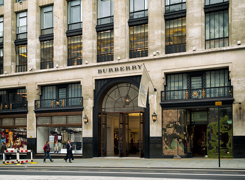 London, England - September 8, 2015: A few people walking past the Burberry store in Regent Street, Central London, on an overcast day. Burberry is a British luxury fashion retailer whose tartan pattern is one of the best known in the world of fashion: the company has over 500 stores in over fifty countries, stocking clothing, accessories, perfumery and cosmetics.