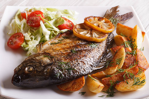 istock fried fish carp with potato and salad on a plate 488514354