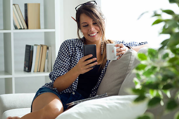 istock Beautiful young woman using her mobile phone at home. 488518642