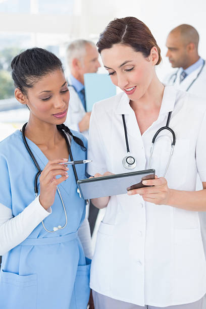 istock Beautiful female doctors working together with tablet 488518744