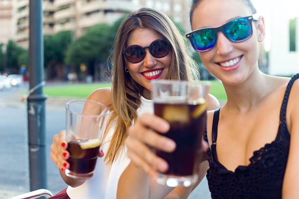 istock Beautiful young women drinking refreshment in the street. 488520276