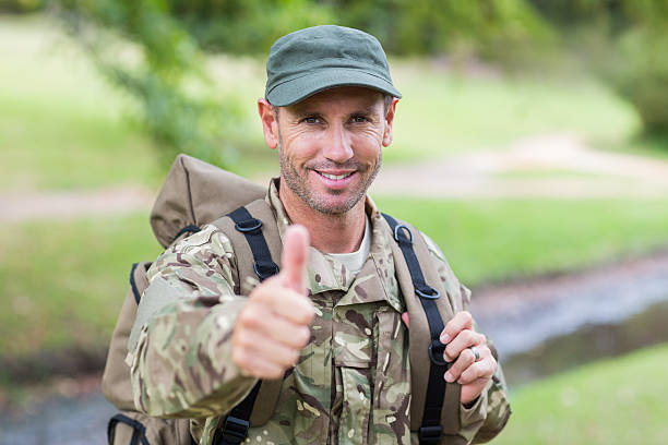 Soldier looking at camera thumbs up on a sunny day