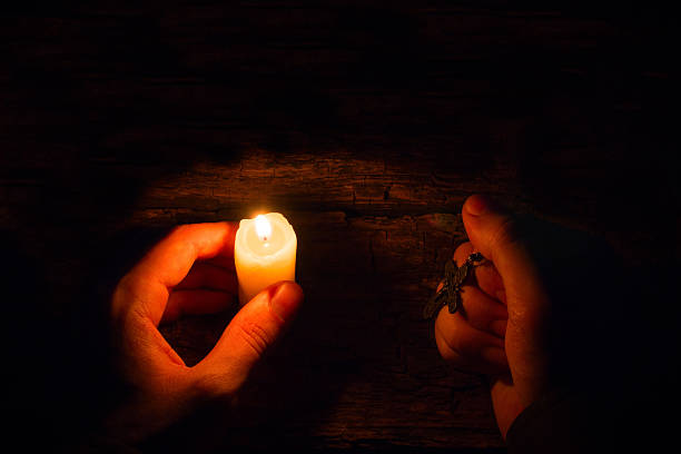 istock believes man with a candle and a cross selective focus 488520418