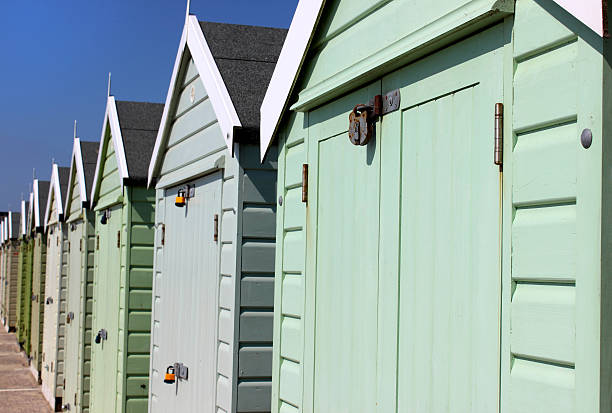 istock Image of colourful English painted beach huts next to cliff 488520551