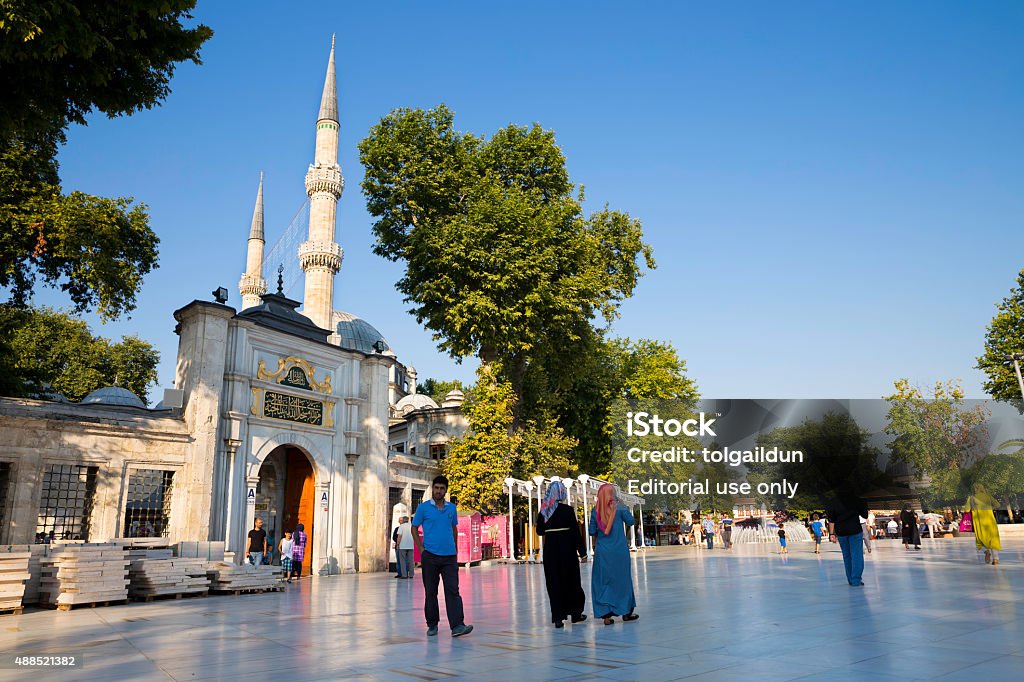 Tourists and Turkish people walking near The Eyup Sultan Mosque Istanbul, Turkey - July 28, 2015: Tourists and Turkish people walking near The Eyup Sultan Mosque, square on a bright day. The Eyup Sultan Mosque is situated in the district of Eyup in Istanbul 2015 Stock Photo