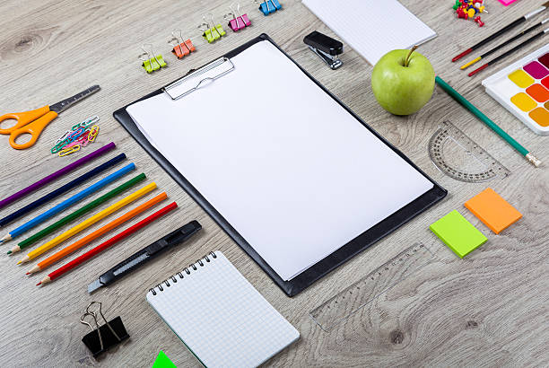 istock Paper, pencils, brush, green apple on wooden table 488522944