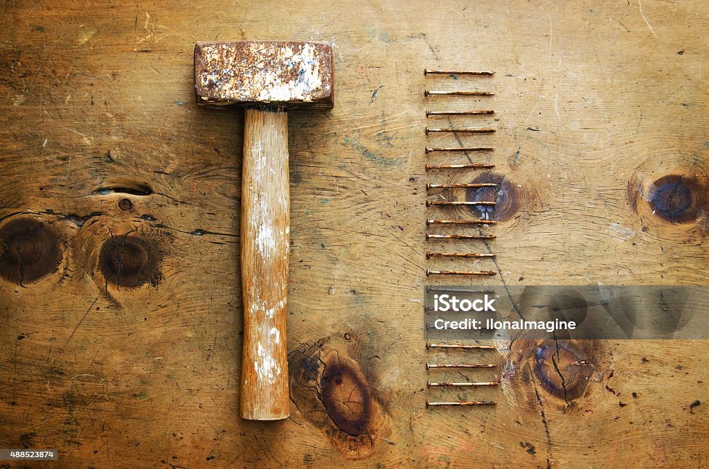 Vintage wood table with hammer and nails Old wood table with hammer and nails in rustic vintage style. Top view. Retro concept background. 2015 Stock Photo